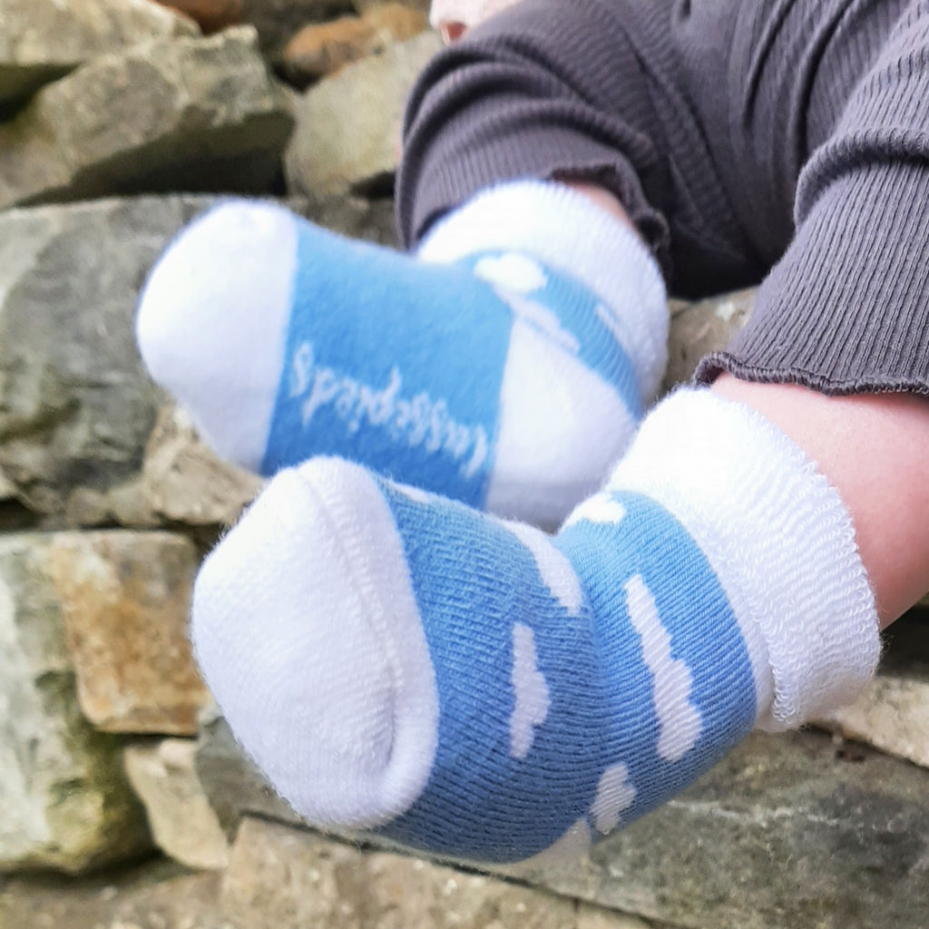 chaussettes fantaisie bleu ciel Nuages sur bébé fond mur de pierre
