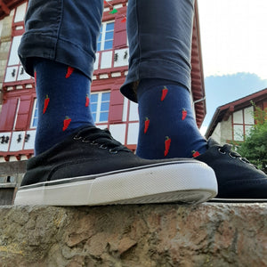 chaussettes Piment d'Espelette portées par modèle devant maison typique Basque 