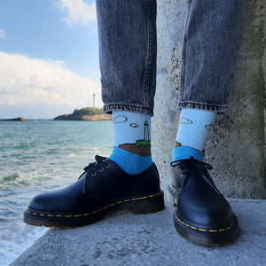 Chaussettes fantaisie motif paysage phare de biarritz ciel et océan pays basque - motif baleine sur pied - marque Cassepieds - sur modèle chaussé de face devant paysage phare de Biarritzl